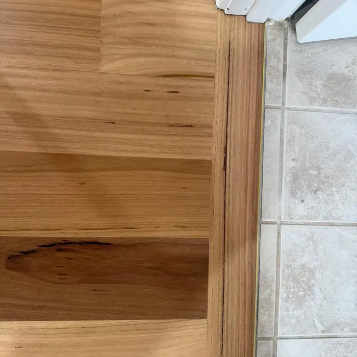 Close-up of a timber floor meeting stone tile