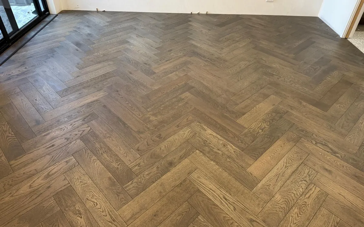 Living room after — smoked oak herringbone flooring installed