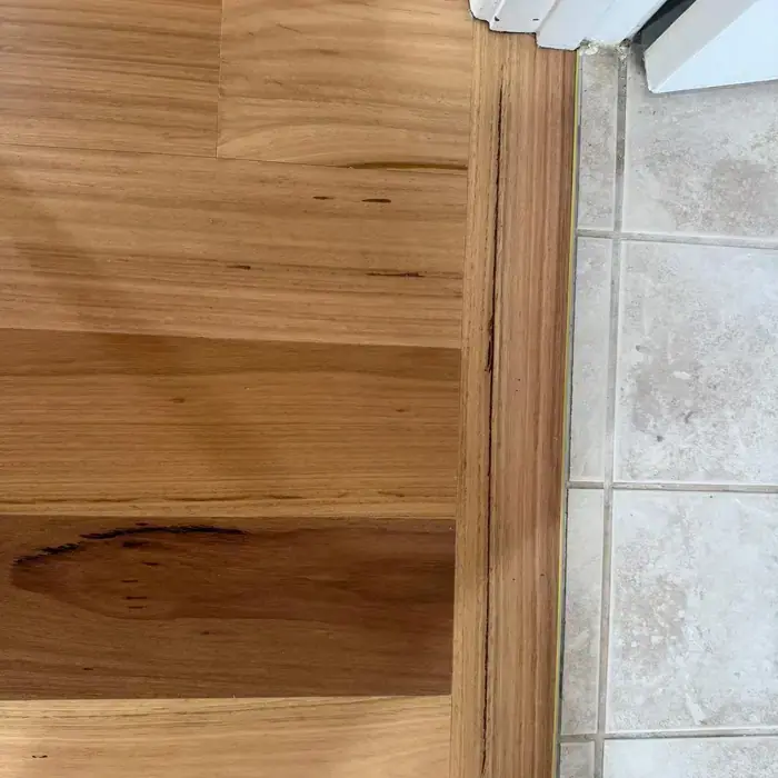 Timber board detail meeting stone tile at a threshold