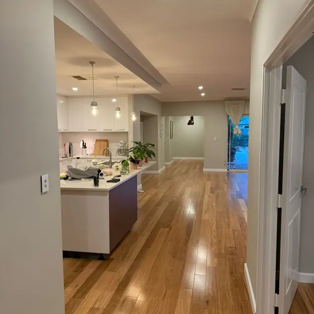 Timber flooring joining a hallway to an open-plan kitchen