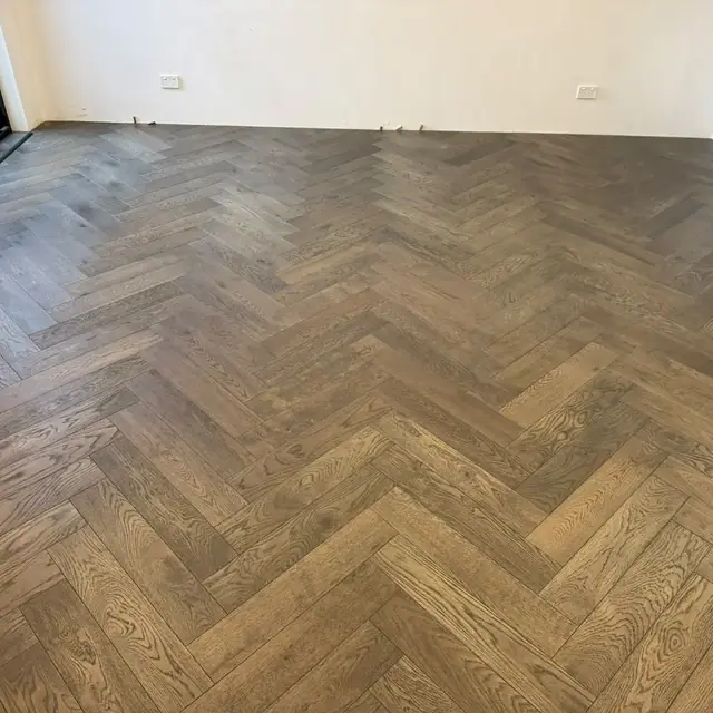 Smoked oak herringbone flooring laid across a Perth living room