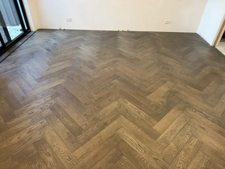 Smoked oak herringbone flooring laid across a Perth living room