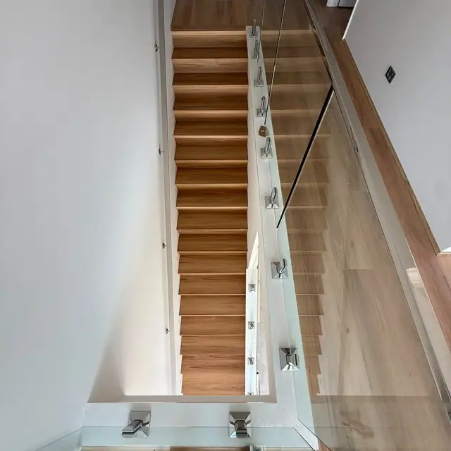 Timber stair treads with a glass balustrade, viewed from the landing