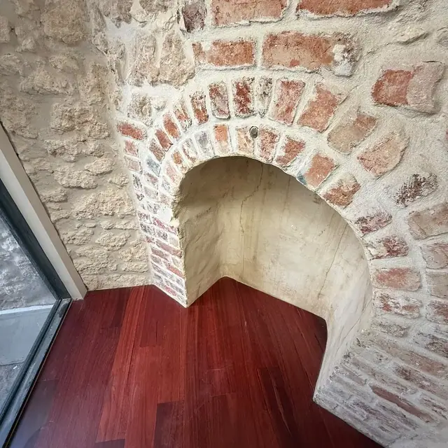 Jarrah flooring and stair base beneath a rendered stone arch