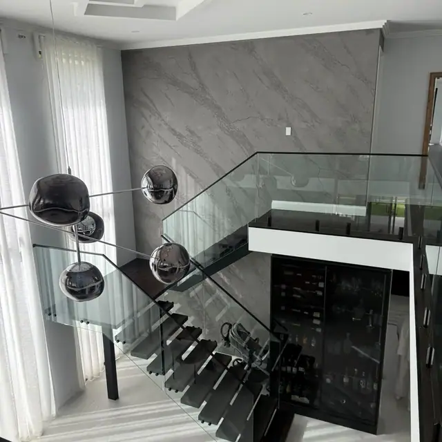 Modern staircase with dark treads and a glass balustrade