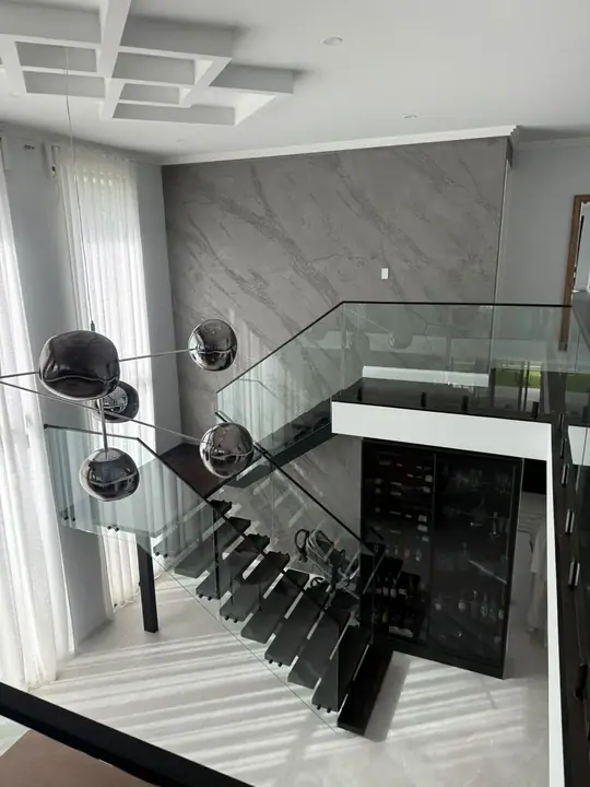 Modern staircase with dark treads and a glass balustrade