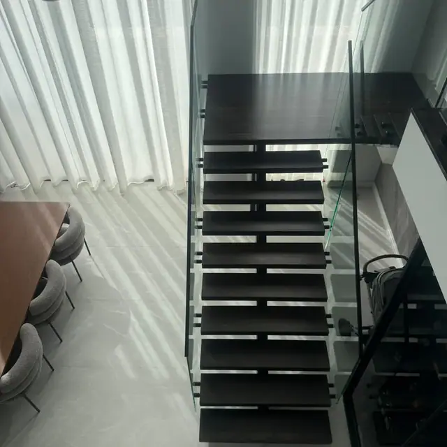 Black timber staircase with a glass balustrade in a Perth home
